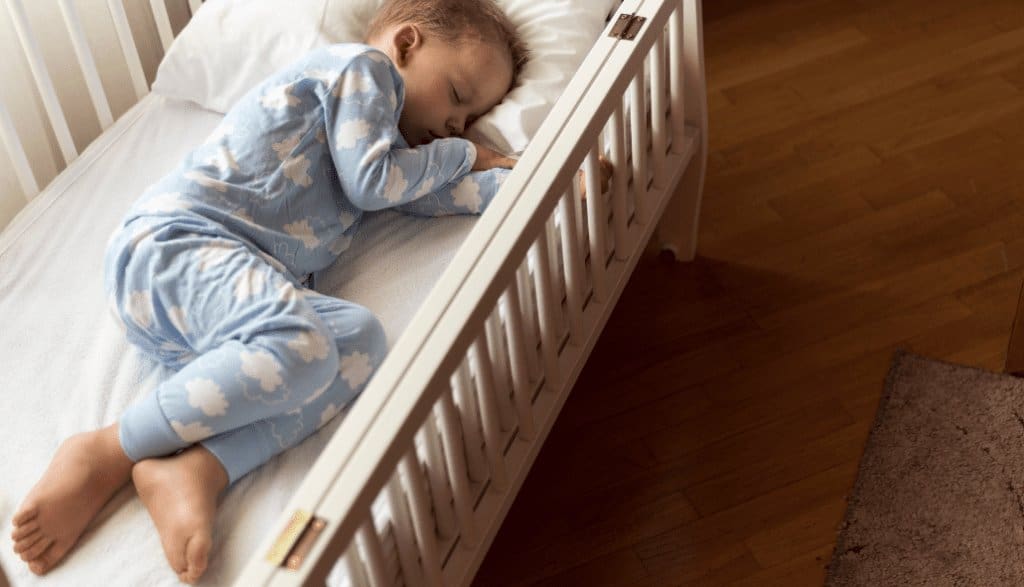 Young boy peacefully sleeping in a toddler bed with soft lighting and cozy bedding, illustrating healthy sleep habits for toddlers